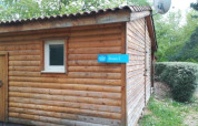 Vista esterna di un lodge in legno chiamato Roses 2 al Chalet Eco, Camping Paradis Les Chanterelles in Francia.