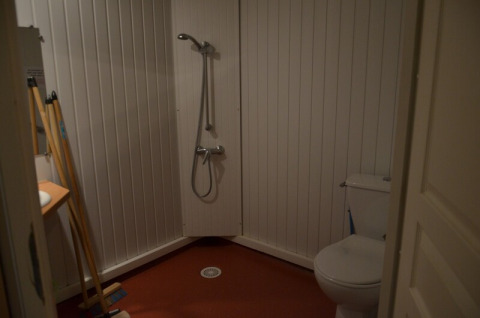 Salle de bain simple au Chalet Eco MIVA, Camping Paradis Les Chanterelles, avec douche, WC et matériel de nettoyage.