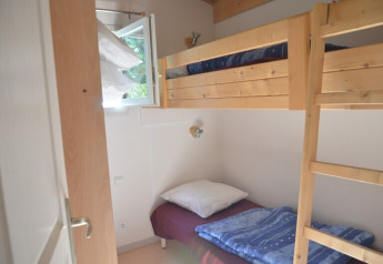 Piccola stanza con letti a castello in legno e finestra aperta presso Chalet Eco MIVA, Camping Paradis Les Chanterelles, Francia.