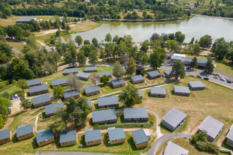 Luftfoto af Camping Holiday Park Les Demeures du Lac ved en sø i Auvergne-Rhône-Alpes, Frankrig.