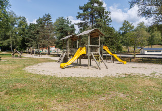Spielplatz mit gelben Rutschen im Ferienpark Les Demeures du Lac in Auvergne-Rhône-Alpes, Frankreich.