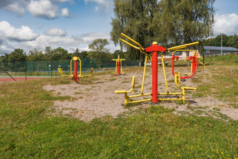 Zona de fitness al aire libre con equipos de ejercicio coloridos en Camping Holiday Park Les Demeures du Lac en Francia.