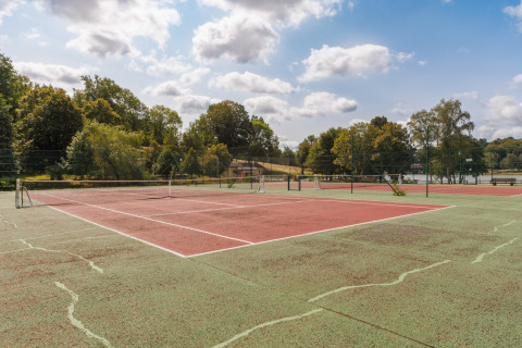 Pista de tenis al aire libre en el parque vacacional Les Demeures du Lac en Auvergne-Rhône-Alpes, Francia.