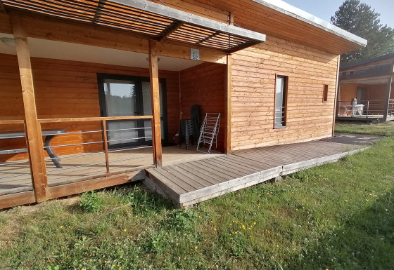 Barrierefreie Holz-Cottage mit Rampe, Terrasse und Garten, ideal für Menschen mit Behinderung.