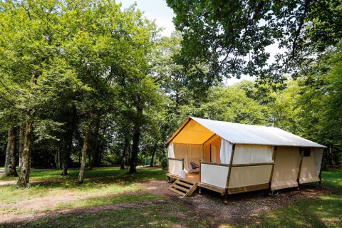 Tenda safari Maasaï Lodge al Seasonova Camping Le Brabois in Francia, immersa tra alberi verdi e natura.