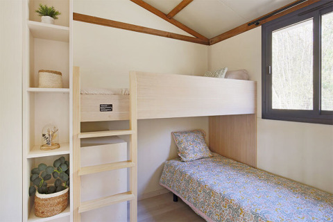 Dormitorio en la cabaña Premium de Seasonova Camping Le Brabois, con literas y gran ventana luminosa.
