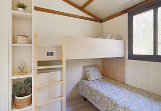 Dormitorio en la cabaña Premium de Seasonova Camping Le Brabois, con literas y gran ventana luminosa.