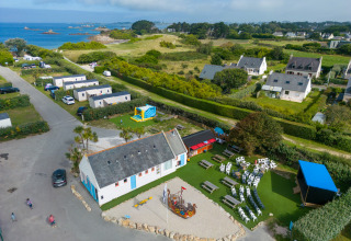 Luftfoto af Camping Seasonova La Pointe de Roscoff, et feriepark i Bretagne med udsigt over havet.