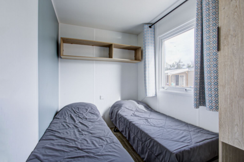 Premium Mobile Home soveværelse hos Seasonova Camping Barberousse i Frankrig med to enkeltsenge.