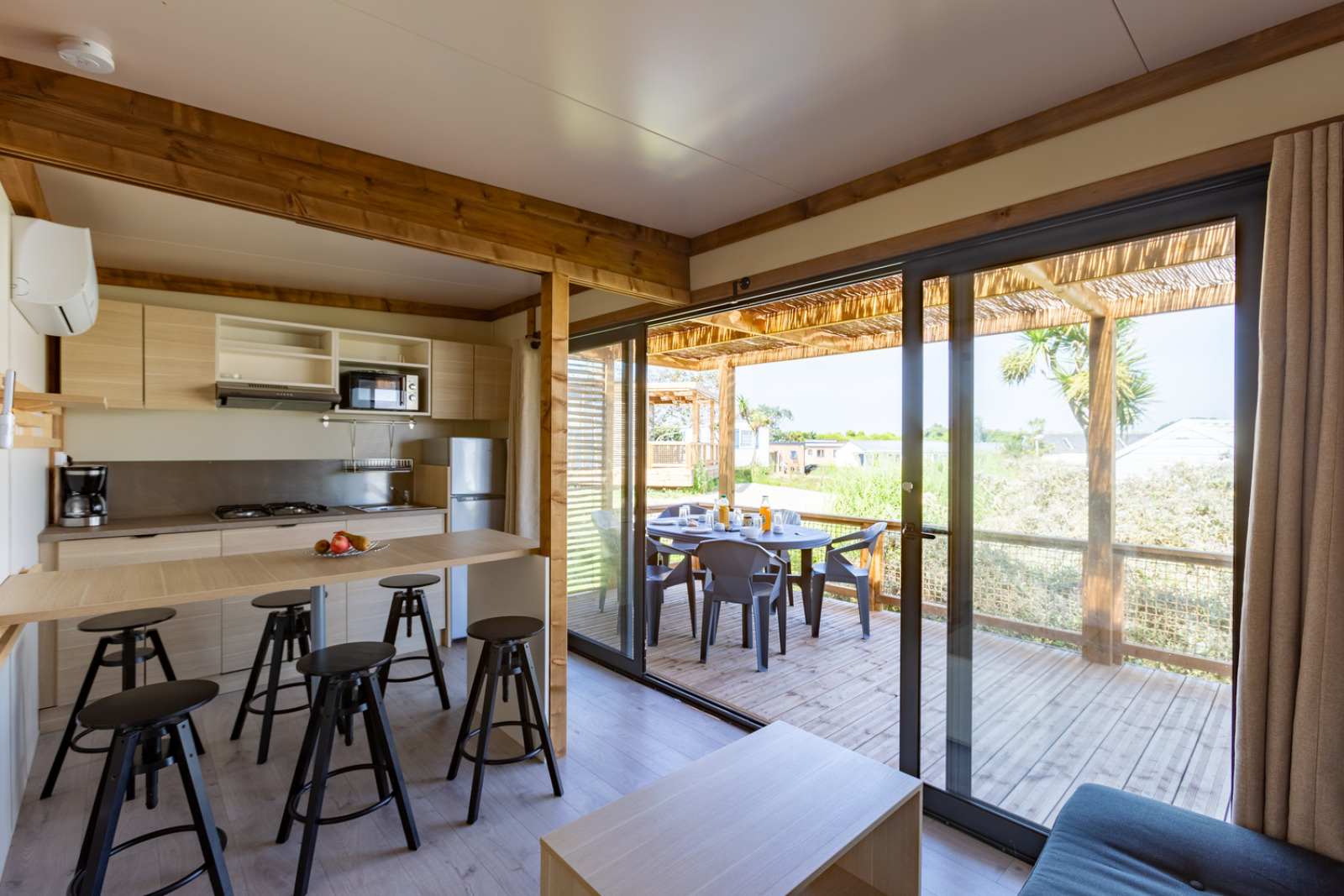 Premium Cottage bij Camping Seasonova La Pointe de Roscoff in Frankrijk met open keuken en zonnig terras.