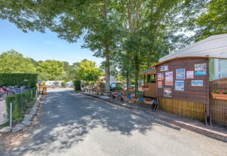 Entrance to Seasonova Camping Le Lac de Cazaux in Occitanie, France, with bikes and trees visible around.