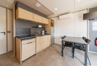 Moderne Lodge-Küche mit Holzmöbeln, Esstisch für vier Personen, Klimaanlage und Wand-TV.
