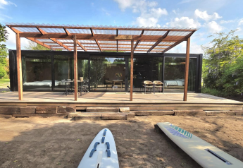 Extérieur du Slowlodge Echo à Zomerlicht aux Pays-Bas, avec terrasse en bois et grande façade vitrée.
