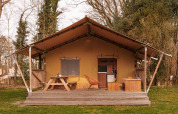 Safari-Zelt De Bos Tent im Gooise Heide, Niederlande; mit Holzmöbeln auf einer Terrasse in der Natur.