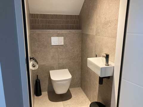 Modern bathroom with wall-mounted toilet and compact sink at Duinvilla, EuroParcs Texel, Netherlands.