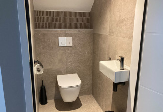 Modern bathroom with wall-mounted toilet and compact sink at Duinvilla, EuroParcs Texel, Netherlands.