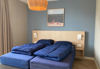 Bedroom at Duinvilla in EuroParcs Texel, Netherlands, featuring blue bedding and contemporary decor.