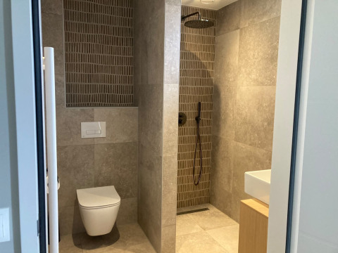 Modern bathroom at Duinvilla, EuroParcs Texel, Netherlands, showing shower, toilet, and sink area.