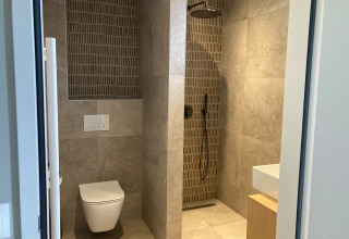 Moderne badkamer in Duinvilla, EuroParcs Texel, met douche, toilet en wastafel in Nederland.