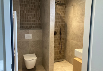 Baño moderno en Duinvilla, EuroParcs Texel, Países Bajos, con ducha, inodoro y lavabo visibles.