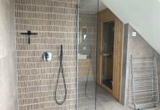 Modern shower and sauna in the bathroom of Duinvilla at EuroParcs Texel in the Netherlands.