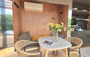 Moderne spiseplads med blomster, puder og aircondition i en lodge ved Slowlodge Echo, Zomerlicht, Holland.