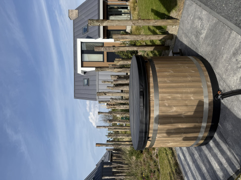 Houten hot tub met zwart deksel voor een moderne lodge bij Duinvilla, EuroParcs Texel, Nederland.