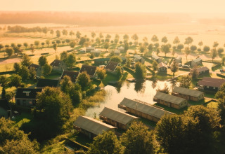 Luftfoto af Group lodge ved Holiday park Eigen Wijze i Holland, omgivet af grønne marker og træer.