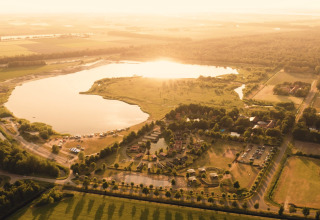 Luftaufnahme der Group lodge im Ferienpark Eigen Wijze in den Niederlanden mit See und Feldern.