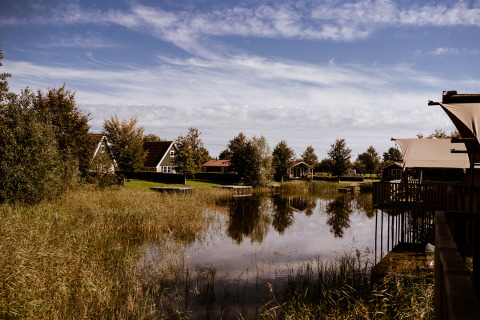Scenic view of Group lodge at Holiday park Eigen Wijze in the Netherlands, surrounded by water.