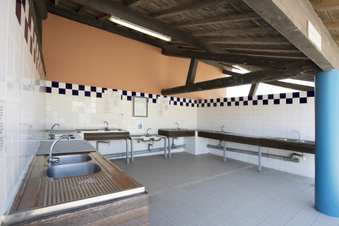 Fælles opvaskerum med flere vaske og vandhaner på Seasonova Camping Barberousse i Occitanie, Frankrig.