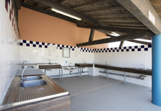Fælles opvaskerum med flere vaske og vandhaner på Seasonova Camping Barberousse i Occitanie, Frankrig.