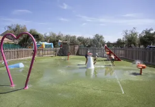 Kinderen spelen op een buitenwaterspeelplein met fonteinen in het Seasonova Camping Barberousse, Frankrijk.