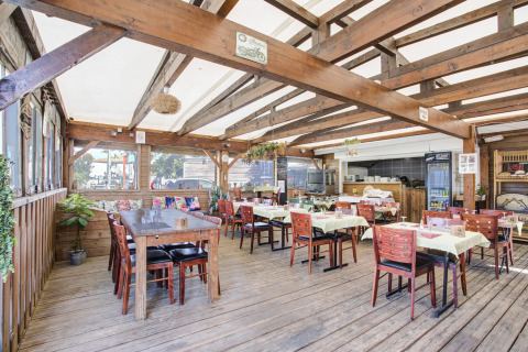 Gezellig overdekt restaurant bij Seasonova Camping Barberousse in Occitanië, Frankrijk, met houten details.
