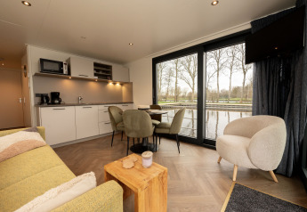Soggiorno luminoso e cucina su Houseboat Offingawier a Welcome In - Friesland con vista sull’acqua.