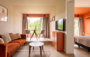Lichte, moderne Tiny House XL bij De Kremmer, Nederland, met oranje accenten en grote ramen.