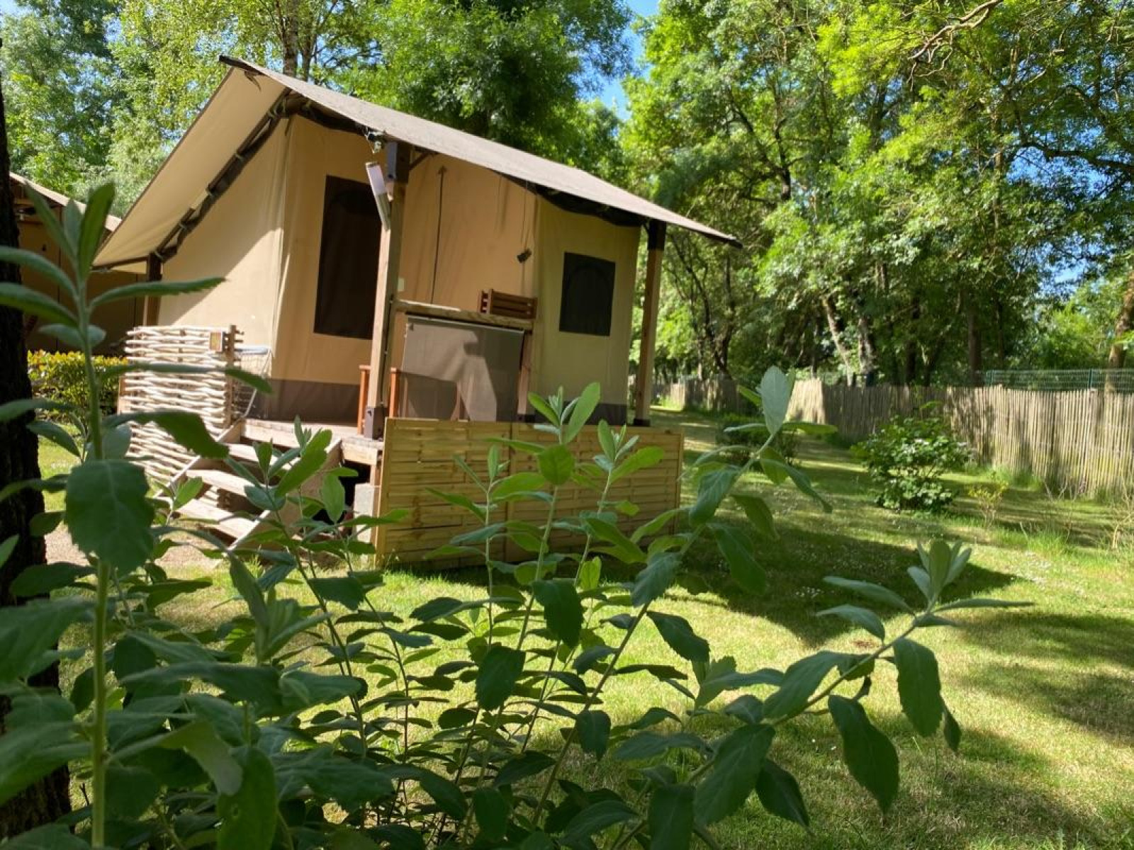 Safaritent Lodge Balearic op Camping les Rives de Grand Lieu in Frankrijk, omgeven door groen.