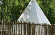 Tenda tipi al Camping les Rives de Grand Lieu in Francia, circondata da alberi e una recinzione in legno.