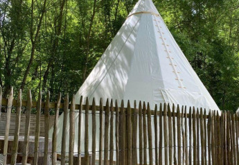 Tenda tipi al Camping les Rives de Grand Lieu in Francia, circondata da alberi e una recinzione in legno.
