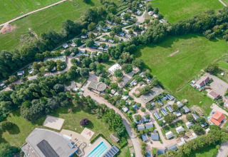 Vista aérea de Camping Paradis Le Giessen en Grand Est, Francia, con piscina, caravanas y zonas verdes.