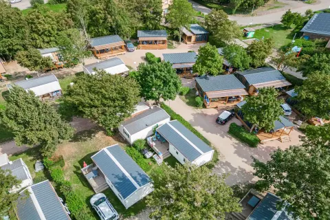 Vista aérea del Camping Paradis Le Giessen en Grand Est, Francia, con cabañas rodeadas de árboles.
