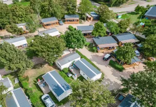 Vista aérea del Camping Paradis Le Giessen en Grand Est, Francia, con cabañas rodeadas de árboles.