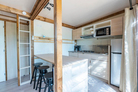 Cocina moderna y comedor en Cottage Premium 3 en Camping Paradis Le Giessen, Francia.
