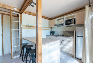 Cocina moderna y comedor en Cottage Premium 3 en Camping Paradis Le Giessen, Francia.
