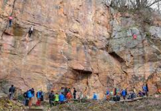 Menschen beim Klettern an einer Felswand nahe Wasselonne, Grand Est, Frankreich, mit Zuschauern unten.