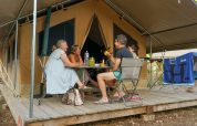 Vier personen genieten voor een safaritent bij Onlycamp Camping l'Orée d'Alsace in Frankrijk.