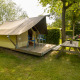 Tente Safari Trekking sur un site de camping avec terrasse en bois, table de pique-nique et chaises.
