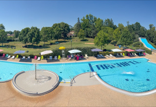 Buitenbad met ligstoelen, parasols en waterglijbaan bij Onlycamp Camping le Champ d’Eté, Frankrijk.