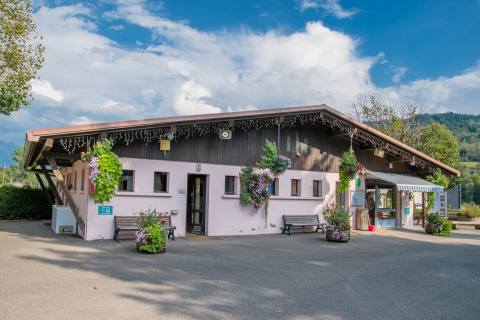 Vakantieparkgebouw met bloemen bij Onlycamp Camping Les Thézières in Auvergne-Rhône-Alpes, Frankrijk.