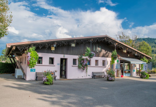 Gebäude des Ferienparks mit Blumen bei Onlycamp Camping Les Thézières in Auvergne-Rhône-Alpes, Frankreich.